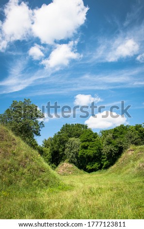 Fantastic landscape with meadow and beautiful hills covered with lush green grass
