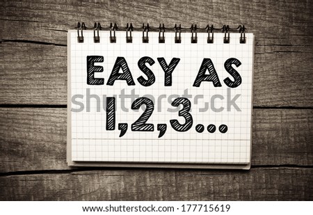 "easy as 123" written in white paper sheet on wooden background Royalty-Free Stock Photo #177715619