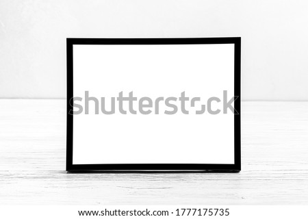 White wooden floor over concrete or decorative plaster wall and black photo frame with copy space for a text background. Mock up for design.