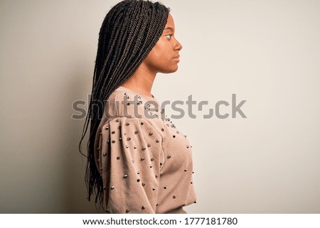 Young african american fashion woman standing casual over brown isolated background looking to side, relax profile pose with natural face with confident smile.
