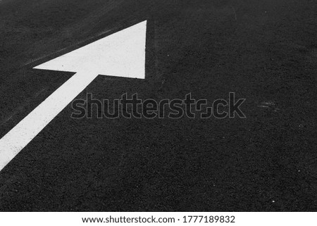 white arrow on asphalt to define direction