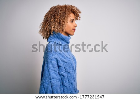 Young beautiful african american woman wearing turtleneck sweater over white background looking to side, relax profile pose with natural face and confident smile.