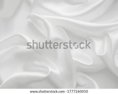 Beautiful elegant wavy white satin silk luxury cloth fabric texture, abstract background design. Copy space. Wedding, engagement concept.