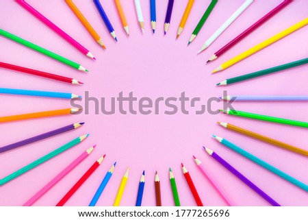Colorful pencils on pink background, mockup, round layout, flat lay, top view, copy space
