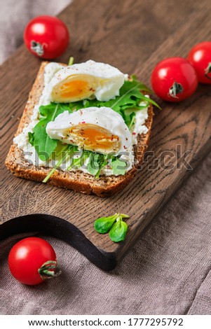 Whole grain sandwiches with guacamole and egg. Breakfast on a wooden board.