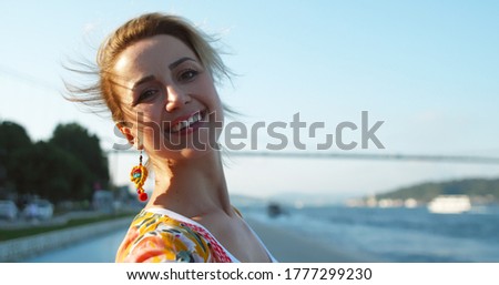 Attractive young beautiful woman on the Bosporus in Turkey poses for the camera.