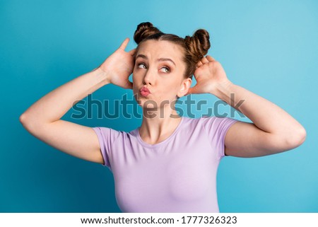 Photo of attractive teen lady touch check nice hairstyle two funny pretty buns hairdo like new style look flirty empty space send kisses wear casual t-shirt isolated blue color background