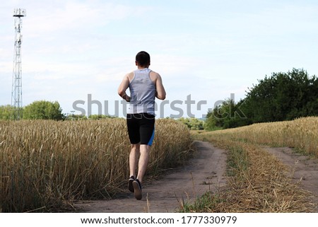 attractive man running near rye field and wearing sport dress