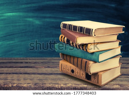 Old study books on a wooden table.