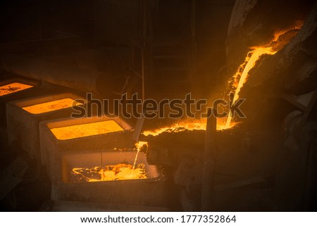 Tank pours liquid metal in the molds by carousel machine Royalty-Free Stock Photo #1777352864