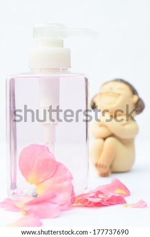 Clear plastic bottle with pink rose petals on white background.