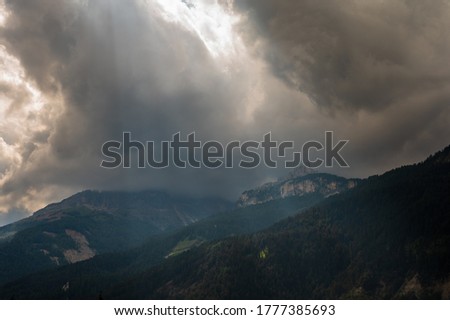Catinaccio group seen by Pozza di Fassa inside the Dolomite mountain range with a cloudy sky in the background, Italy