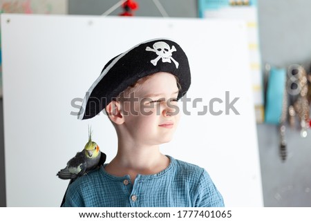 Boy in a pirate hat with a parrot on his shoulder