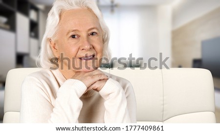 Peaceful happy middle aged old woman resting on cozy sofa at home.