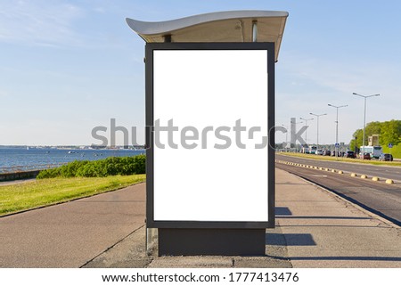 glass bus stop by the sea, with a white advertising space. Blank billboard and outdoor advertising. Mockup poster outside. Tallinn, Estonia.