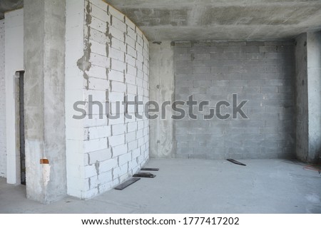 Beginning the renovation of a new apartment with concrete and brick walls in a new residential building.  Royalty-Free Stock Photo #1777417202