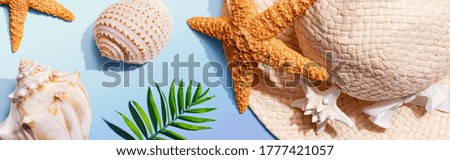 Summer concept with a straw hat and starfish overhead view - flat lay