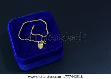 Gold bracelet on the blue box isolated on a black background