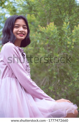 Portraits smiling Asian young girl with pine tree in vintage color.