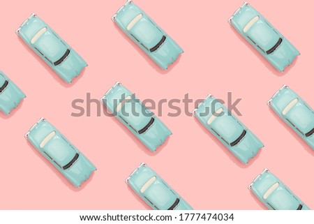 blue classic toy cars isolated on pink background. objects in pattern. minimal image.