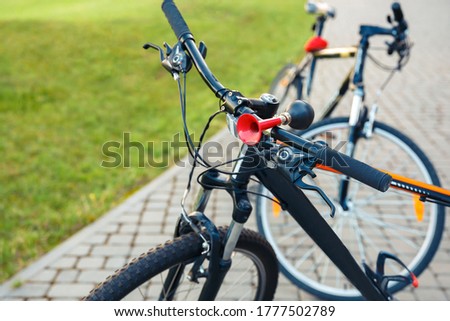 Bicycle wheel while close up. A bicycle is parked in a city park.