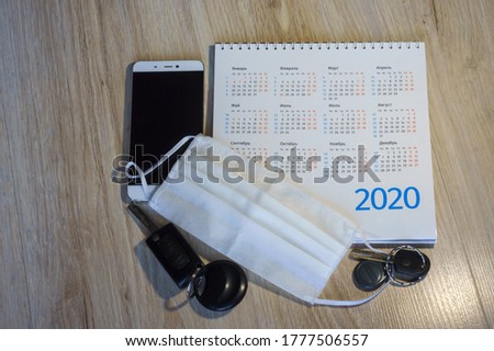 medical mask and phone on the table, white medical mask and calendar for 2020, medical mask and keys