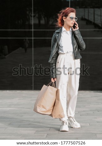Woman in leather jacket with mobile phone. 