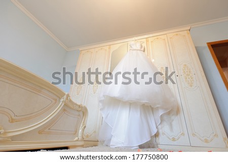 luxury wedding dress hanging on wardrobe