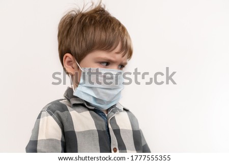 Serious little boy in a medical mask