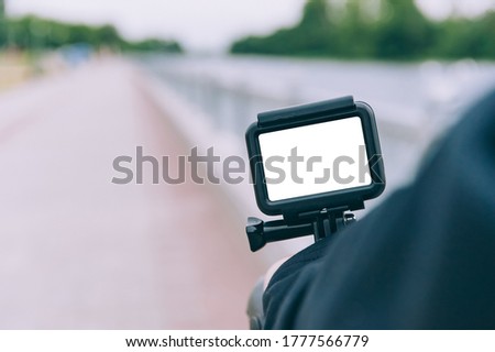 Man with an action camera on his hand, against the background of nature