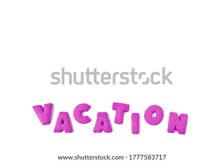 Text of VACATION spelled with purple alphabet shaped biscuits on a white background