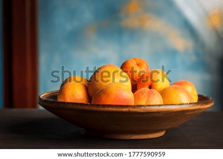 Ripe Apricot fruit isolated on a wooden table in a bowl closeup