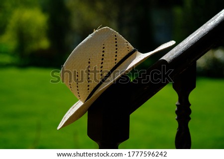 Straw Hat hanging in the green garden. Selective focus