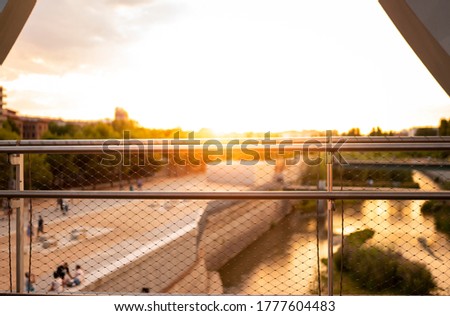 sunset in a city, fence on a bridge