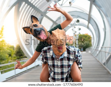 Crazy and stylish people- Fashion couple wearing t-rex and dog mask, Absurd, vacation and funny trend concept -