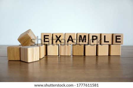 Concept word 'example' on wooden cubes on a beautiful white background. Wooden table. Copy space. Business concept.