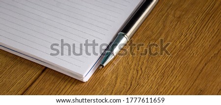 Notebook and pen on wood table. Business and education concept.