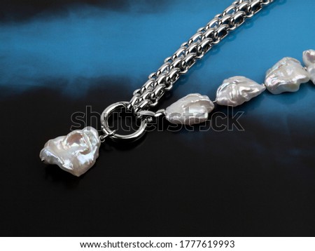 Luxury elegant baroque pearl necklace with pendant on gradient black blue background. Close-up shot