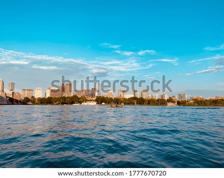 This is a landscape picture taken on the water in Cambridge Mass, looking into downtown Boston. 