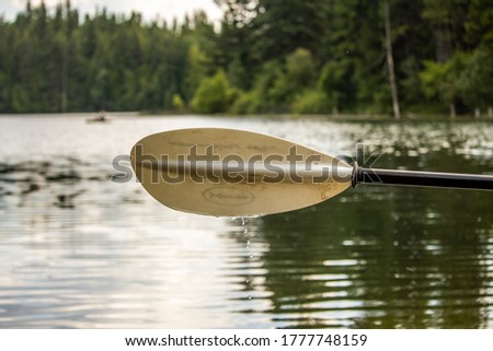 Picture of a dripping paddle over a calm lake