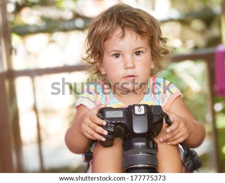 cute child girl with photo camera at home on natural background