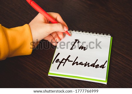 International left-handers day. Holiday August 13th. Woman lefty writes in a notebook.