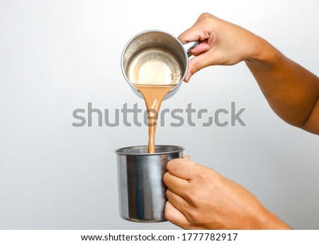 A close up picture of men preparing "teh tarik". Sweet milk tea been pull for mix well and create foam that is famous in Malaysia and South Asia region. Royalty-Free Stock Photo #1777782917