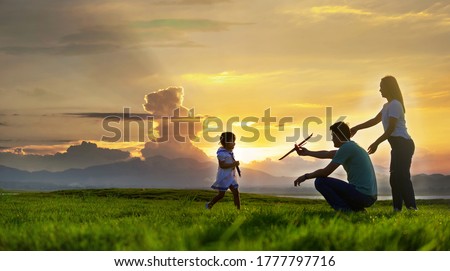 Asian families are happy in the wide fields after sunset.
