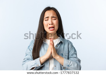 Lifestyle, people emotions and beauty concept. Desperate sad and clingy asian girl sobbing and crying while begging help, apologizing with hands in plead, telling how sorry she is Royalty-Free Stock Photo #1777837532