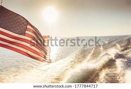 American Flag Waving in the Wind While on the Water and Under the Sunset