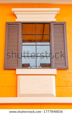 Vintage window with orange wall, Thailand.
