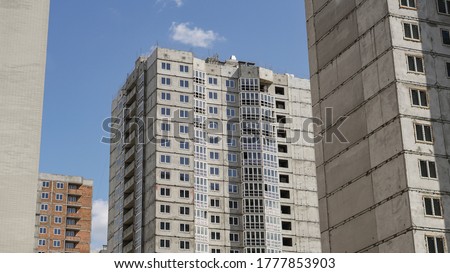 Large construction site on a background of blue sky. Brick, panel apartment building. Industrial theme for design