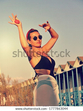 Belly Dancer dancing at the beach with a key for copy space in her hand , concept of holiday and summer time