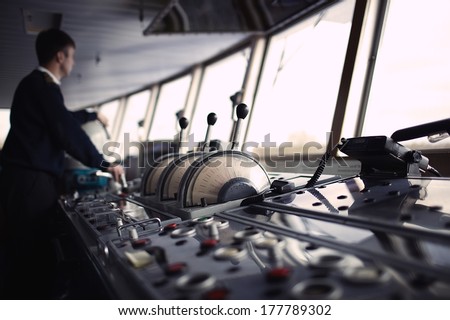 Navigation officer driving the ship on the river. Color corrected in film tones Royalty-Free Stock Photo #177789302